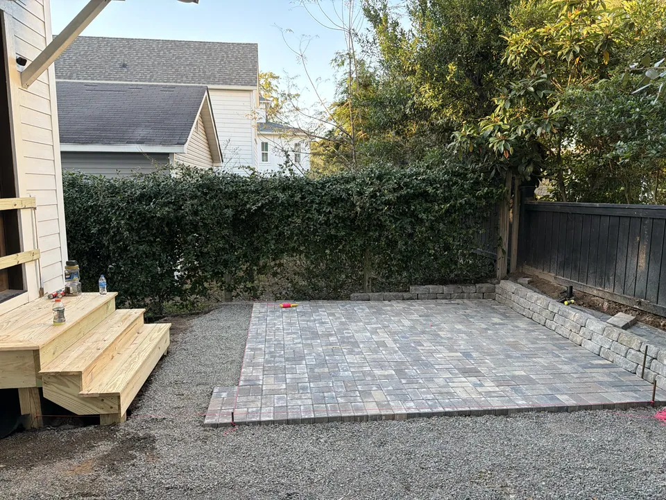 Finished gray paver patio beside the back steps